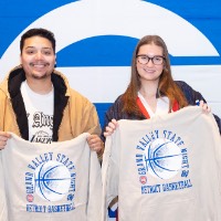 Girl and boy with their new sweatshirts in front of GV backdrop